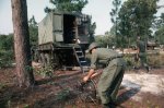 US Army soldier lays down wire for the AN_MRC-69 radio terminal set mounted on the M35 cargo tru.jpg